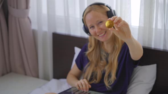 Woman a Music DJ Holds an NFT Coin in Her Hand alt