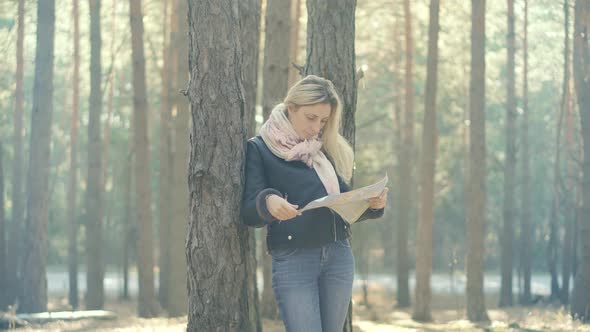Woman Tourist Paper Map.Tourist Lookin On Map.Traveler Explore Forest With Map.Autumn Forest alt
