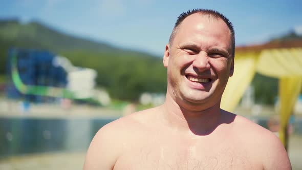 Close-up, Portrait: Man on Beach, Bare-chested, Laughs. There Are Drops of Water on His Body. Short alt