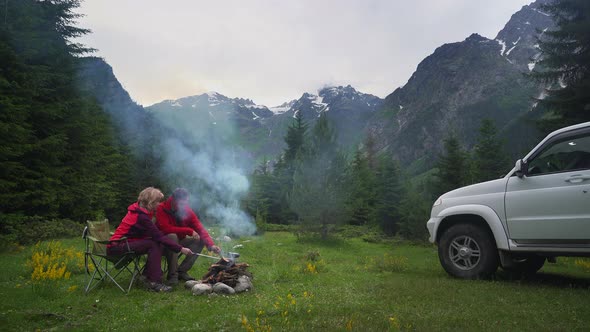 Couple Chatting By Bonfire in a Camping in a Dark Mountain Valley