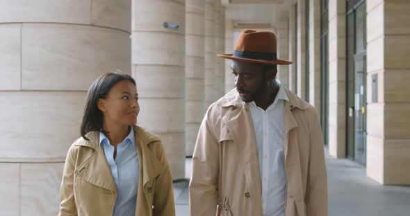 Slider Shot of Two African Colleagues in Stylish Formal Wear Walking Outdoors Downtown alt