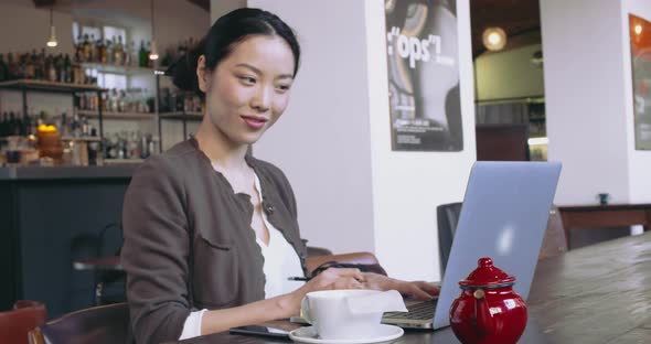 Woman Using Laptop with Tea Cup