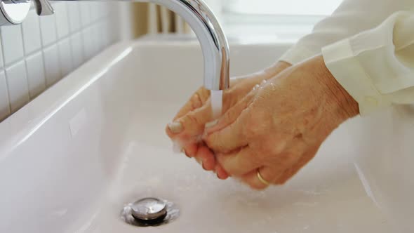 Senior woman washing her hands in sink 4k alt