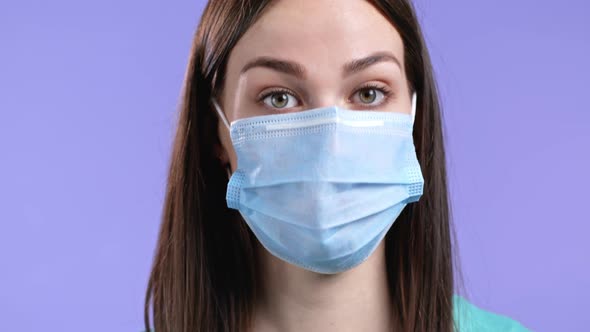 Cheerful Woman with Protective Facial Mask Showing Yes Sign Nods Her Head Approvingly alt