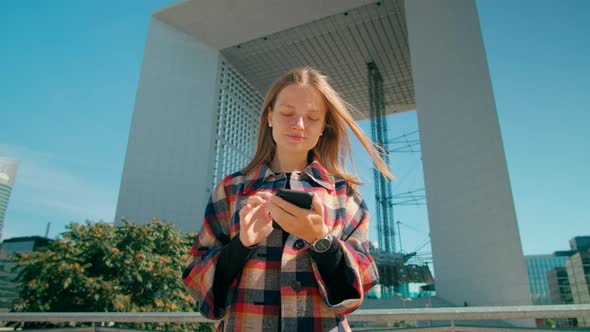 Millennial European Business Woman Uses Smartphone App in Paris Downtown France