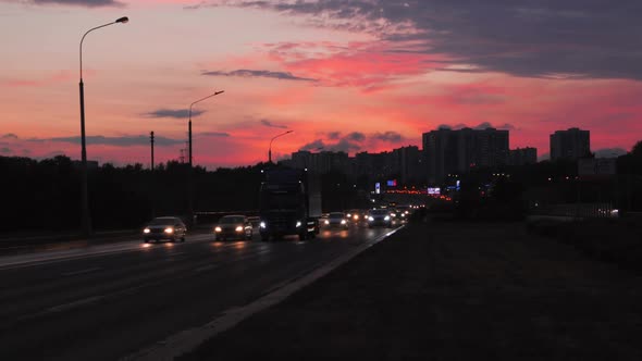 Beautiful Bright Orange Pink and Purple Sunset Sky City Highway Road Traffic alt