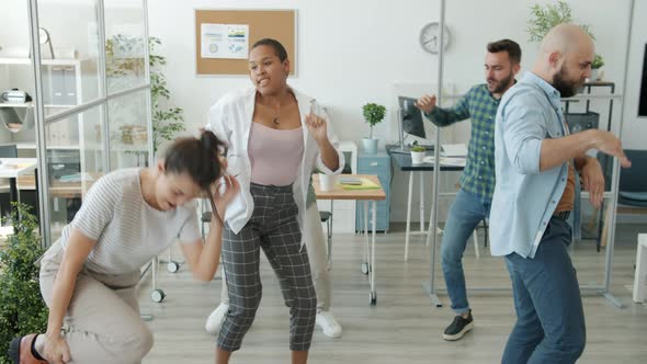 Crazy Young People Girls and Guys Dancing in Workplace Making Funny Movements and Faces alt