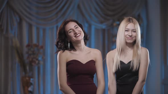 Beautiful girls in dresses laughing at the camera