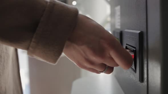 A Woman's Hand Makes a Banknote To the ATM