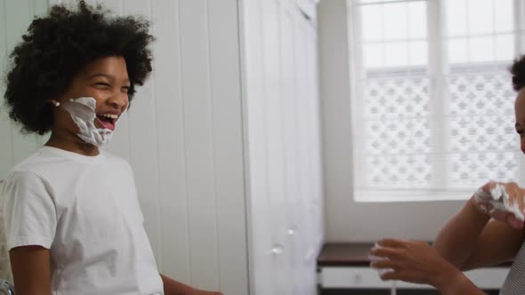 Mixed race mother and daughter having fun in bathroom alt