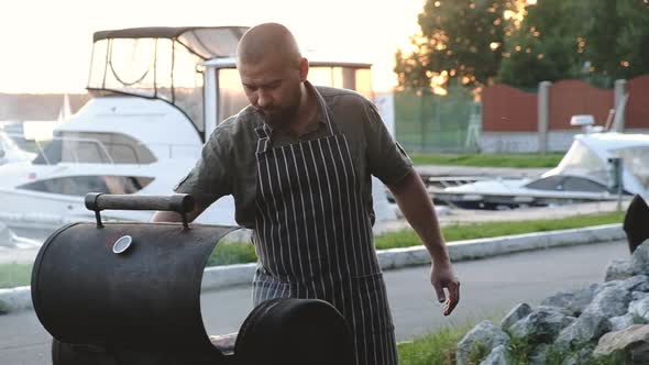 chef is frying large piece of meat on grill for group of friends.