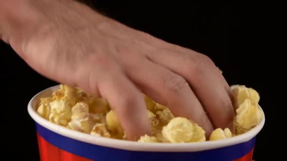 Hands Grabbing Popcorn on Black, Slow Motion alt