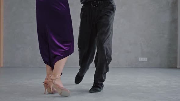 Shot of Pair of Dancers Legs Performing Tango in Grey Studio