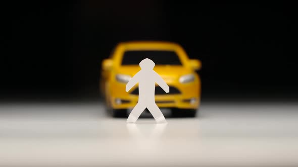 Yellow toy car knocks down a male figure