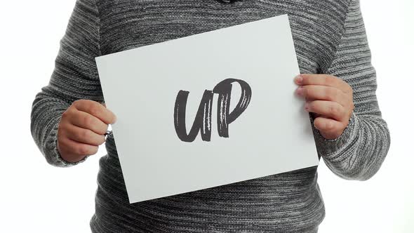 A person holding a sign with the message and the word "up" alt