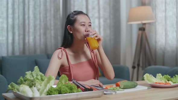 Asian Woman Drinking Orange Juice Then Smiling To Camera While Having Healthy Food At Home alt