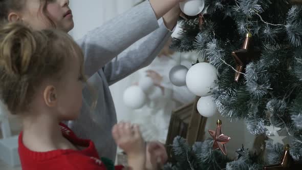 Happy American family celebrating Christmas. Children open a gift at home. alt