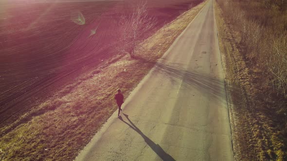 Aerial View of Woman Farmer with Digital Tablet Computer Looks at a Fresh Plowed Field After Winter alt