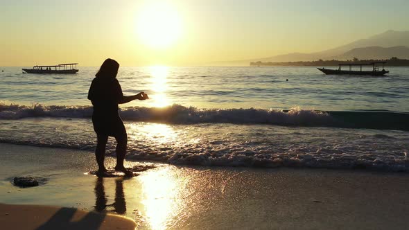 Modern smiling girl travelling enjoying life at the beach on summer white sandy and blue background  alt