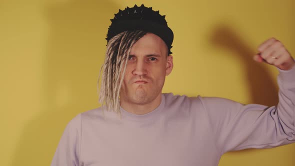 Young Handsome Man in Black Cap Showing Strength with Hands alt