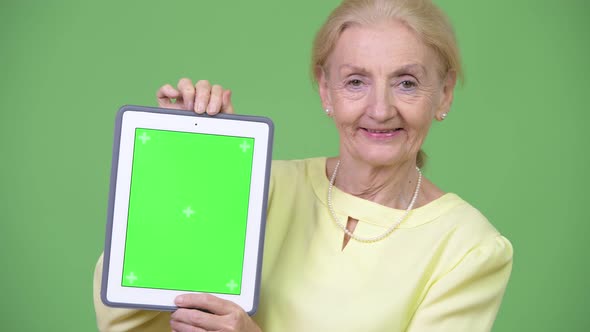 Beautiful Happy Senior Businesswoman Showing Digital Tablet alt