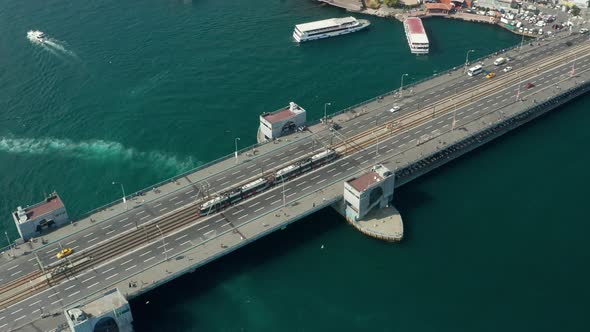 Public Transport Tram Train Passing Galata Bridge Over Bosphorus in Istanbul with Boats on Water alt