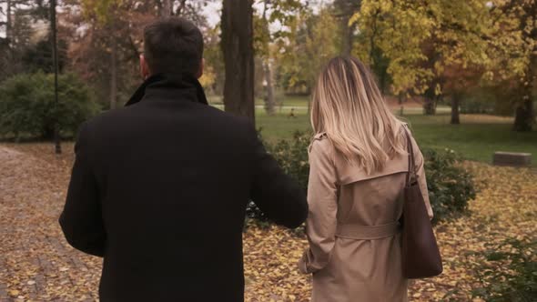 Handsome young couple in the autumn park with electrical bicycle