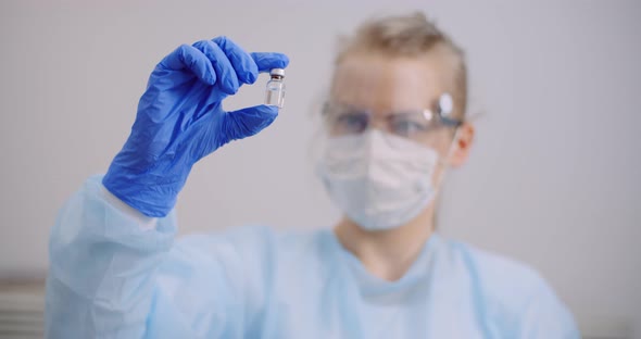 Doctor Holding and Examining Medicine in Hands alt