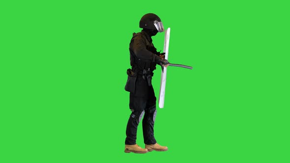 Riot Policeman Hitting Shield with the Baton While Walking on a Green Screen Chroma Key alt