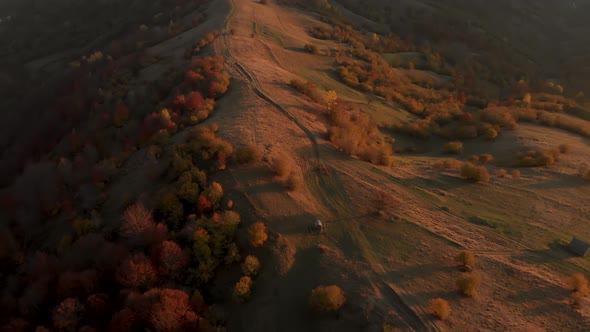 Flying Over Dirt Road on Mountain Hill with Autumn Forest Around