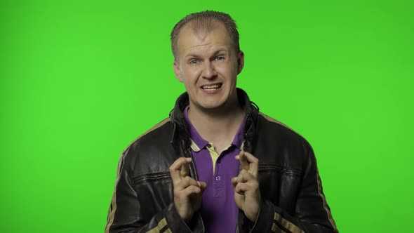 Rocker Man Full of Hope Crossing His Fingers Showing Good Luck Gesture, Wishing for Fortune, Winning alt