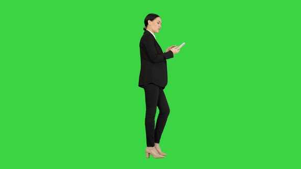 Disapprovingly Looking Business Woman Using Her Phone on a Green Screen Chroma Key alt