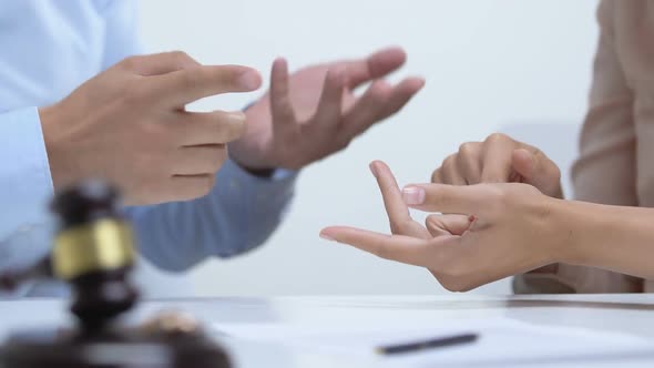 Couple Arguing in Court, Gavel With Engagement Rings on Table, Divorce Concept alt