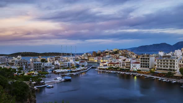 Timelapse, tilt, zoom out of beautiful sunset over Greek town and bay on Crete, Greece