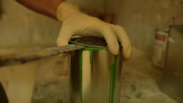 Close Up of Painter Opening a Can of Green Color alt