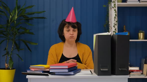 Sad Lonely Business Woman Sitting at Workplace Alone with a Birthday Hat