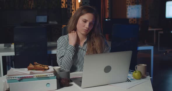 Tired Woman Having Pain and Touching Her Neck While Working Late in Office. Girl Office Manager alt