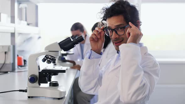 Scientist with Microscope Working in Laboratory