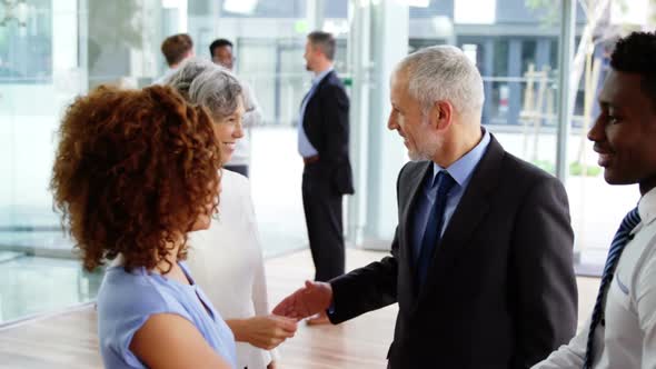 Businesspeople shaking hands in office alt