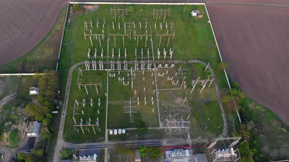 Quadrocopter flight over the power plant. Rows of poles, wires. City power station from above.