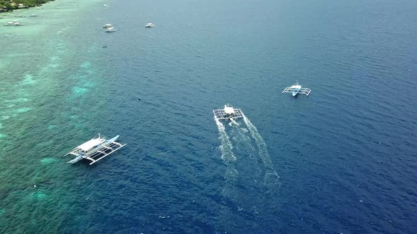 Wooden Boats Sailing Across Blue Sea In Moalboal Cebu Philippines alt