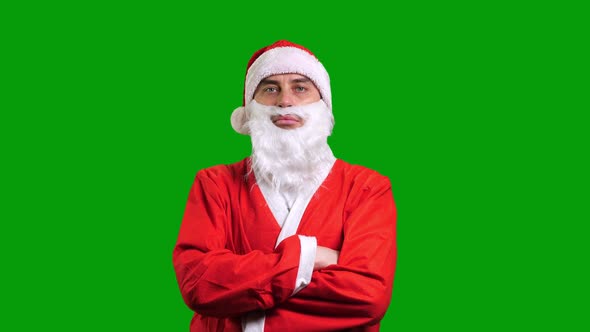 Santa Claus in Red Costume with Crossed Hands on Green Chroma Key Background alt