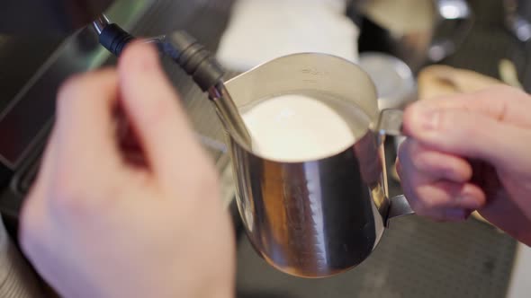 the Hands of the Barista Steamed the Milk Into a Thick Foam in the Pitcher and Rubbed the Tip of the alt