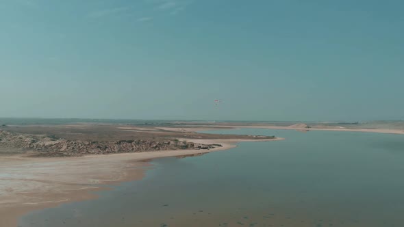 Aerial View Of Motorised Paraglider Flying Over Salt Lake In The Distance alt