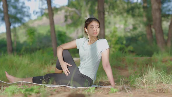 Asian cute girl She is doing yoga in the morning in the garden by the beach.