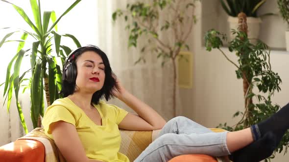 Female woman in headphones with eyes closed listening to music