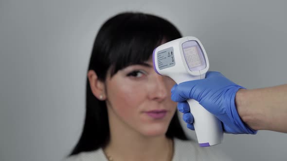 Close Up Video of Contactless Thermometer Used To Check Temperature Brunette Young Female alt