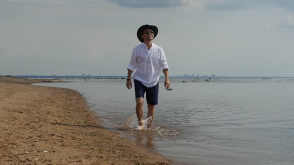 Good Looking Man in Cowboy Hat Walking on Sandy Beach