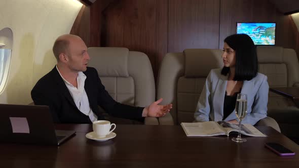 A young Couple a Man Drinking Coffee a Woman Sitting Making a New Business Plan Working alt