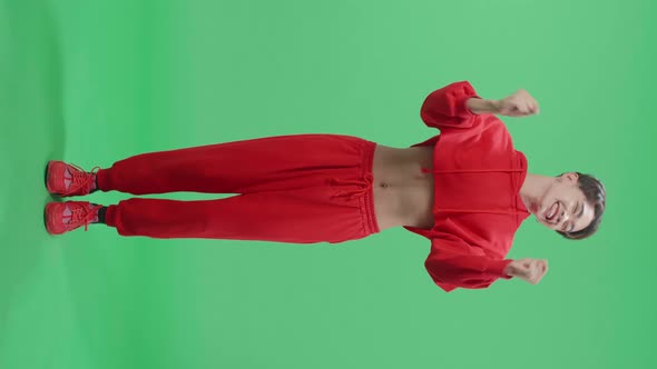 Full Body Of Cheerful Young Asian Transgender Male Celebrating While Standing On Green Screen alt